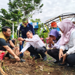 UNNES team and partners planting a tree during an environmental conservation program in Wonolopo, Semarang.