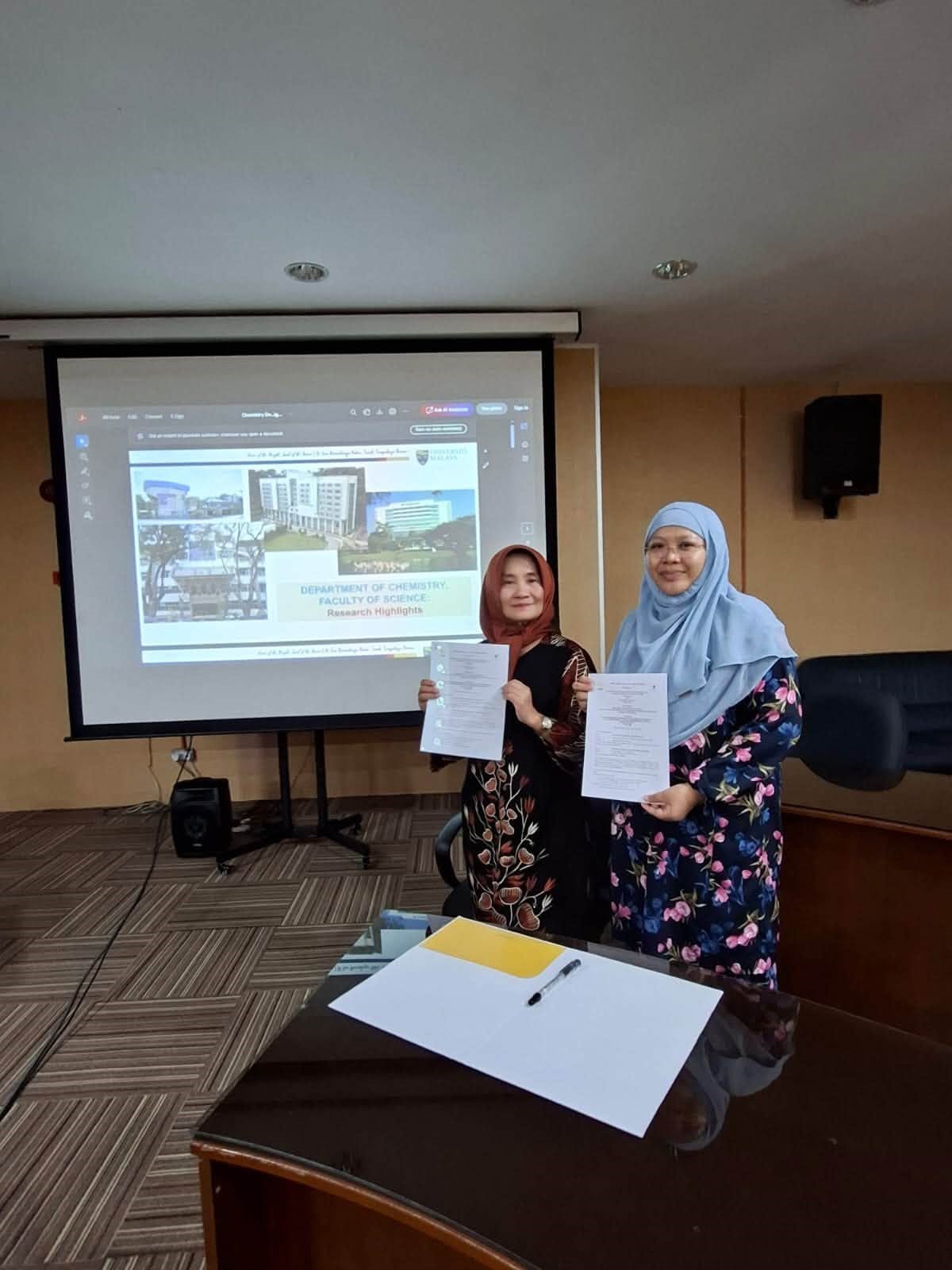 Perwakilan FMIPA UNNES dan Universiti Malaya menunjukkan dokumen kerja sama bidang pendidikan dan riset kimia.