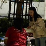Peserta kegiatan GERSOS menyerahkan paket makanan kepada masyarakat.