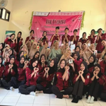 Dozens of Himabio FMIPA UNNES student board members wearing maroon organizational shirts posing with hand hearts alongside elderly residents in front of a banner reading Biology Student Association Social Service.