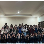 Puluhan mahasiswa pengurus BEM FMIPA UNNES berpose bersama dalam tiga barisan di dalam ruangan sambil kompak membentuk gestur tangan di depan dada.